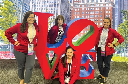 A group of four Pennsylvania Hospital nursing leaders poses with a scaled-down model of the Philadelphia’s LOVE sculpture.